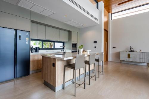 an open kitchen with a large island with bar stools at Botanica Foresta B10 in Phuket