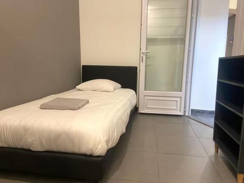 a bedroom with a bed with a laptop on it at ღ Calysta - Studio Proche Centre Ville & Gare in Douai