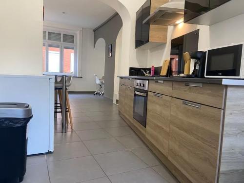a kitchen with wooden cabinets and a counter top at ღ Calysta - Studio Proche Centre Ville & Gare in Douai