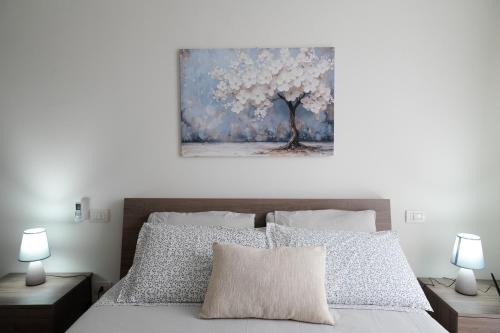 a bedroom with a bed with a painting on the wall at Casa Laura - Home and Relax Malpensa in Lonate Pozzolo