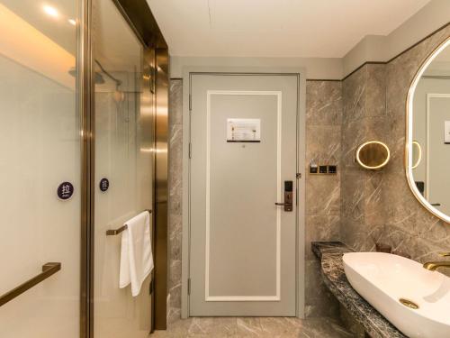 ein Badezimmer mit Waschbecken und Spiegel in der Unterkunft Mercure Xian City Centre in Xi'an