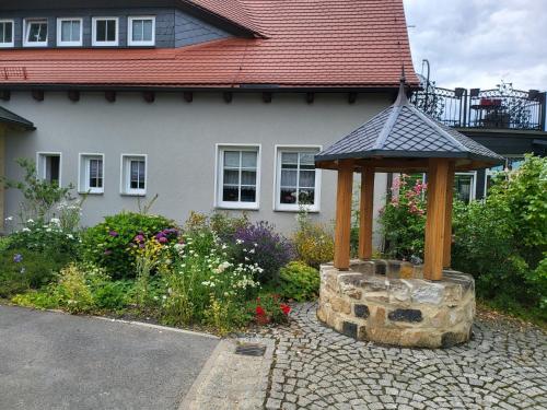 un giardino con gazebo di fronte a una casa di Luxus Ferienwohnung a Kurort Jonsdorf