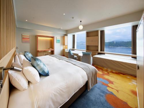 広島市にあるグランドプリンスホテル広島の大きなベッドと大きな窓が備わるホテルルームです。