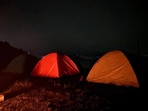 two tents sitting on a hill at night at The Tatwa Hotel & Camping in Chakrāta