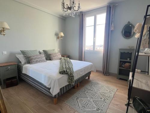 a bedroom with a bed and a chandelier at Golden hours luxury and panoramic view in Nice