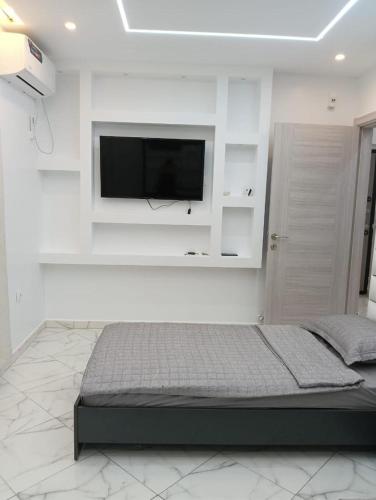 a bedroom with a flat screen tv on a white wall at Maison de repo in Mostaganem