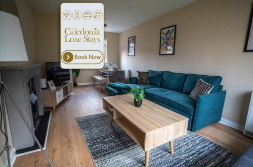 a living room with a blue couch and a coffee table at Castlefern House in Rutherglen