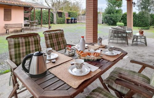Una mesa de madera con una tetera y una cesta de pan. en Villino Celeste, en Bagno Roselle