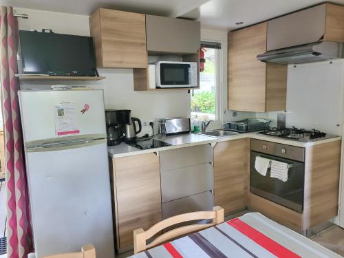 eine kleine Küche mit Kühlschrank und Mikrowelle in der Unterkunft Sevservices à La Réserve in Gastes