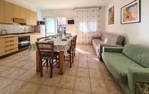 a kitchen and living room with a table and a couch at Milla 2 in Rosolina Mare
