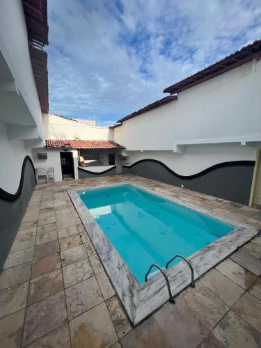 a swimming pool in the courtyard of a house at Eros Motel in Natal