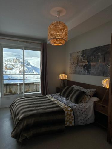 a bedroom with a bed and a large window at Appartements du Pic d'Anie in Arette