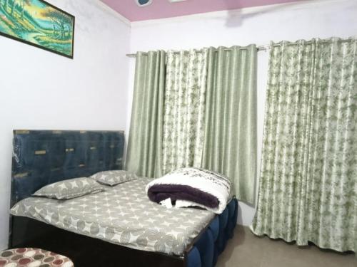 ein Schlafzimmer mit einem Bett und einem Fenster mit Vorhängen in der Unterkunft Prince Home Stay in Jāmb