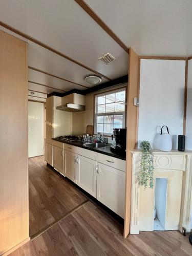 a kitchen with white cabinets and a sink at Vakantiepark Klein Vink - 25 in Arcen