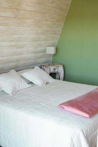 a bedroom with a white bed and a table with a lamp at Brisas del Ceferino in Sierra de la Ventana
