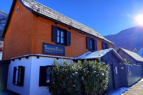 a building with a sign on the side of it at Ferienhaus TraunseeStrand in Ebensee