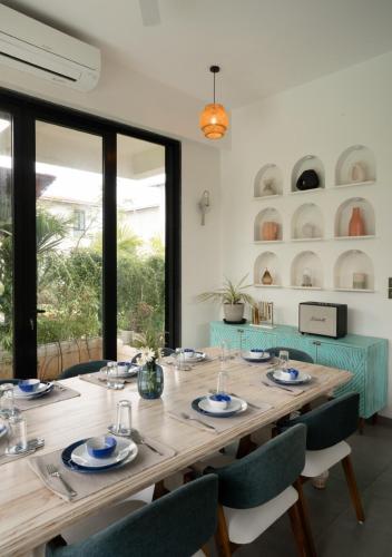 Un comedor con mesa y sillas de madera. en LohonoStays Villa Siena F, en Alibaug
