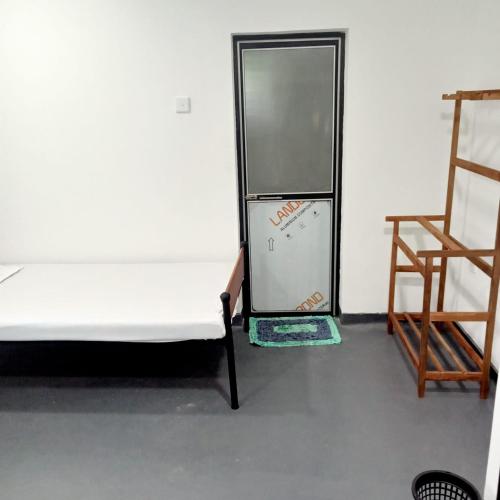 a refrigerator and a chair in a room at Cenesco Rest in Induruwa