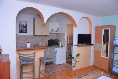 una cucina con due sedie e una cucina con archi di std- Na lepom plavom Dunavu a Kladušnica