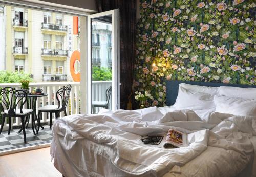 a bedroom with a bed with a floral wall at The Oscar Olympic Hotel in Thessaloniki