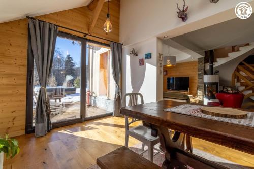 ラ・フェクラにあるLe chalet du lysのテーブルと大きな窓のあるダイニングルーム