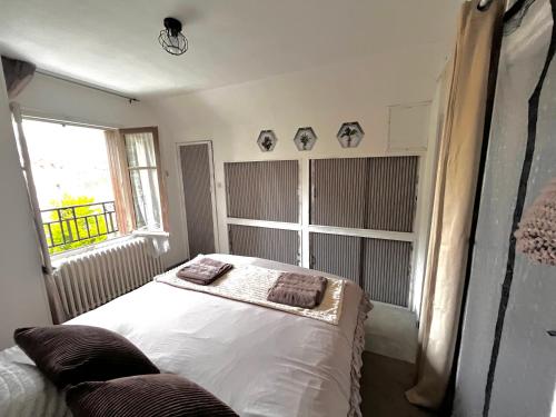 a bedroom with a bed with two pillows on it at Atypique, calme & cosy, proche de Paris in Bonneuil-sur-Marne