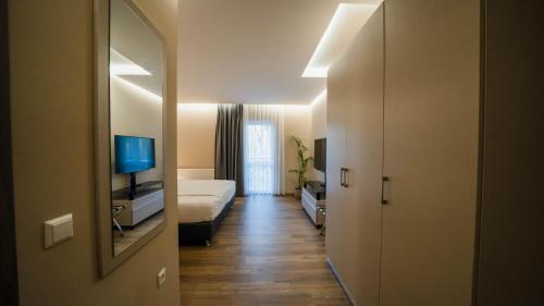 un corridoio di una stanza d'albergo con un letto e una televisione di Comfort Boardinghouse a Stoccarda