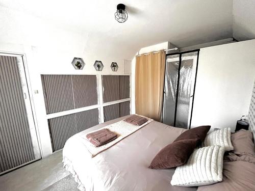 a bedroom with a white bed with pillows on it at Atypique, calme & cosy, proche de Paris in Bonneuil-sur-Marne