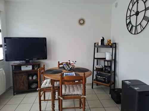 Meublé du centre في نيديربرون ليه باينس: غرفة طعام مع طاولة وتلفزيون