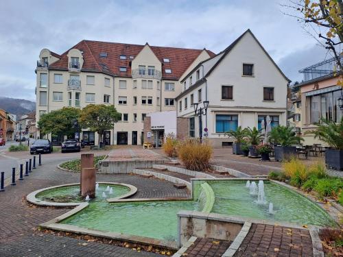una città con una fontana in mezzo a una strada di Meublé 3 étoiles en centre-ville a Niederbronn-les-Bains