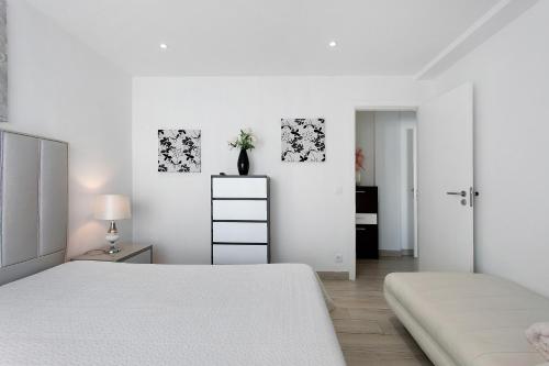 een witte slaapkamer met 2 bedden en een tafel bij Natalina T1 in Pederneira