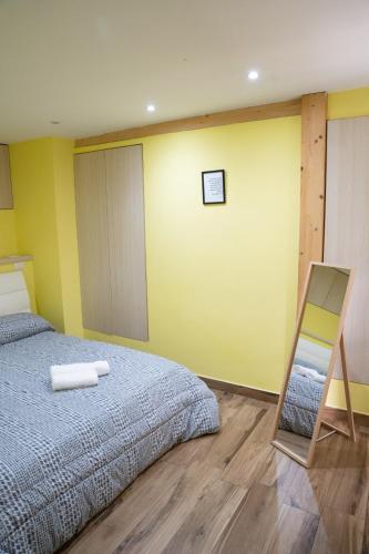 a bedroom with a bed and a yellow wall at Casa vacanze Harmonie in Olevano Romano
