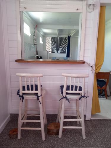 2 sillas sentadas en un bar con espejo en Maryland's, en Grand-Bourg