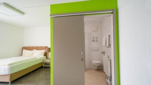 una camera con letto e un bagno con servizi igienici di Comfort Boardinghouse a Stoccarda