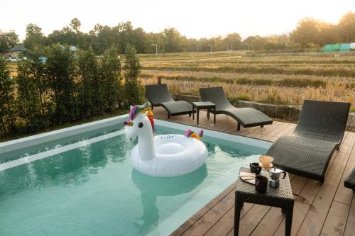 a pool with a inflatable swan in the water at Pai Prestige - Luxury Pool Villas in the centre of Pai in Pai