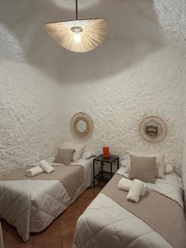 a bedroom with two beds and a chandelier at Bike Cueva - Desierto in Gorafe