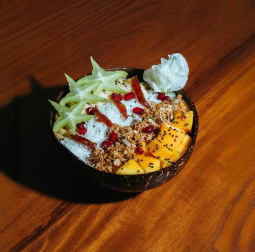 een kom eten zittend op een houten tafel bij Casa Tharin Madiha in Matara