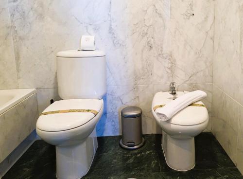 a bathroom with two toilets and a sink and a tub at Loft 21.Estilo con vistas de cine in Valladolid