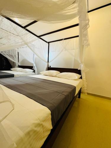 un dormitorio con una cama con dosel en Hotel Elysian, en Udawalawe