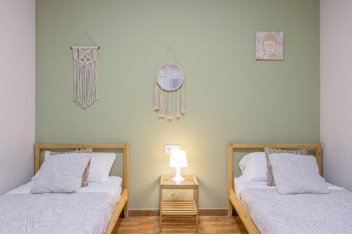 Dos camas una al lado de la otra en una habitación. en La Bella Escondida, en Cádiz