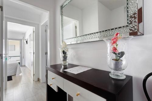 Una encimera negra con un jarrón y un espejo en Natalina T2, en Pederneira