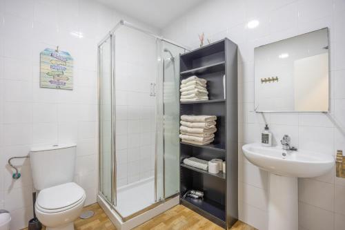 Un baño con inodoro, ducha y lavabo. en La Bella Escondida, en Cádiz
