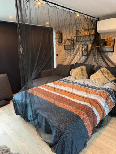 a bedroom with a bed with a mosquito net at B&B Wellness Garden in Herzele