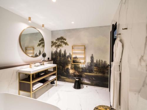 a bathroom with a large painting on the wall at Aigle Noir Hotel Fontainebleau - MGallery Collection in Fontainebleau