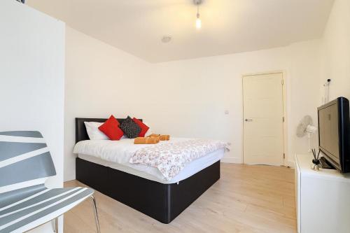 a white bedroom with a bed and a tv at 1 Bedroom Apartment By The River in High Wycombe