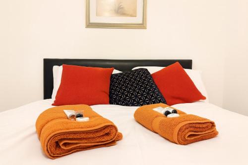 two towels on a bed with pillows on it at 1 Bedroom Apartment By The River in High Wycombe