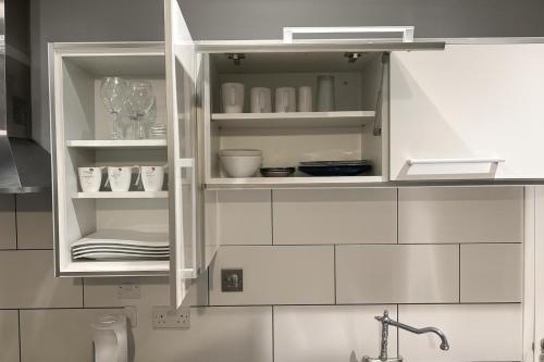 a kitchen with white cabinets and a sink at 1 Bedroom Apartment By The River in High Wycombe