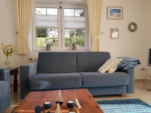 un soggiorno con un divano blu e un tavolo di Mien Dröm, Wohnung 1 a Baltrum