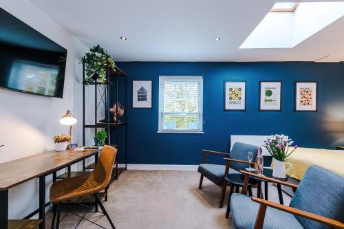 a bedroom with blue walls and a table and chairs at Riverside Studios in the Centre of Chester in Chester