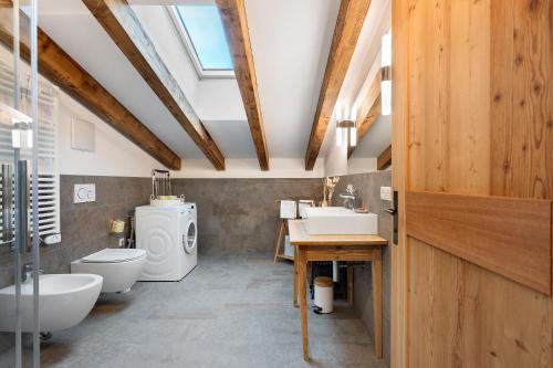 a bathroom with two sinks and a toilet and a window at Alpin Chalet Samer Apt Fürstenblick in Sarntal